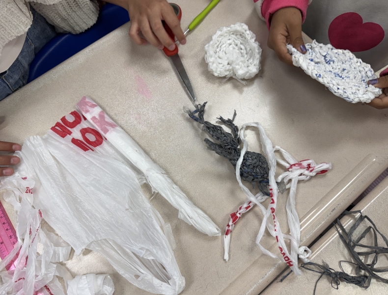 Students crochet with plarn, or plastic yarn made from recycled grocery bags, as part of a sustainability project at Belvoir Elementary School.