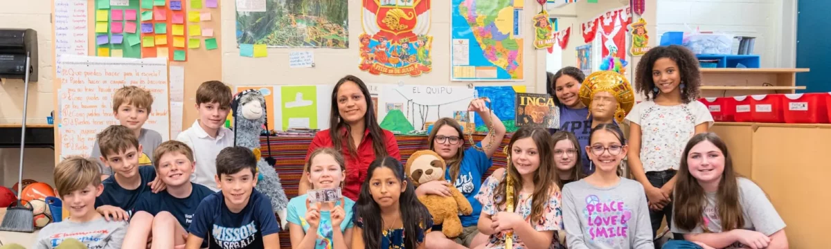 Class of students posed with their international teacher