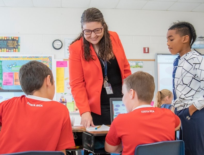 Dual language teacher helping students improve language proficiency