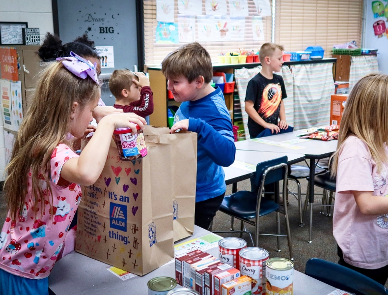 Students developing global competencies by helping with a food drive