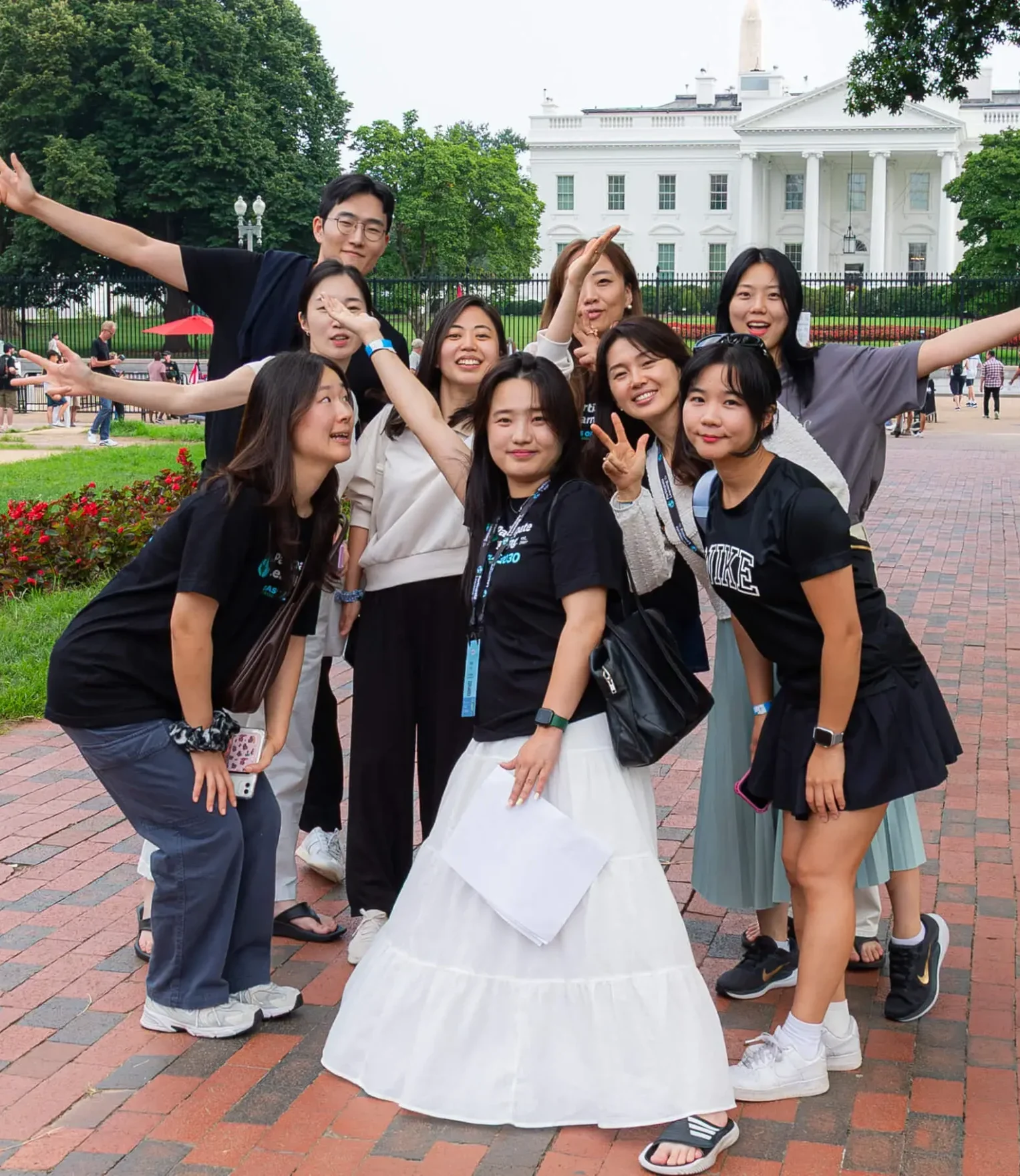 Energetic group of South Korean teachers posing joyfully in front of the White House in Washington, D.C., celebrating their arrival in the USA to teach through the J-1 visa cultural exchange program, sponsored by Participate Learning; showcasing international educators ready to bring global perspectives to American classrooms.