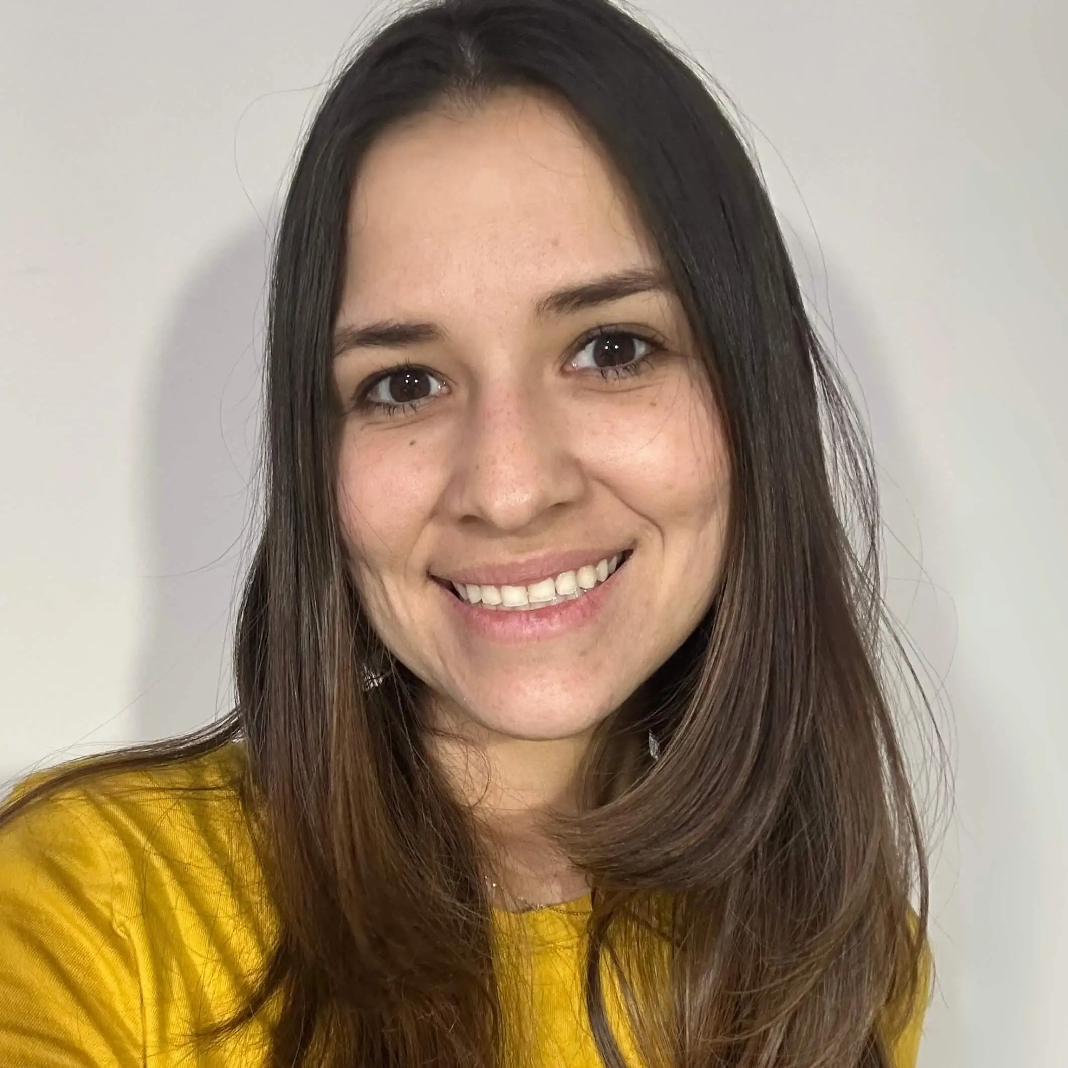 Smiling teacher from Colombia in yellow shirt