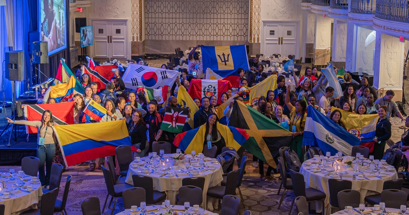 Participate Learning exchange teachers from around the world wave their national flags during orientation, celebrating global connection and cross-cultural collaboration.
