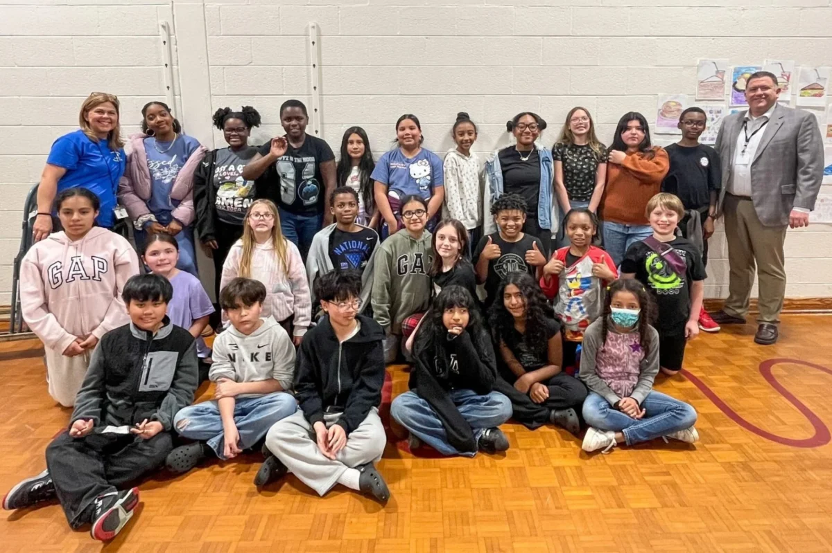 Students pose for a picture to celebrate being the class with the most donations for the school food drive.