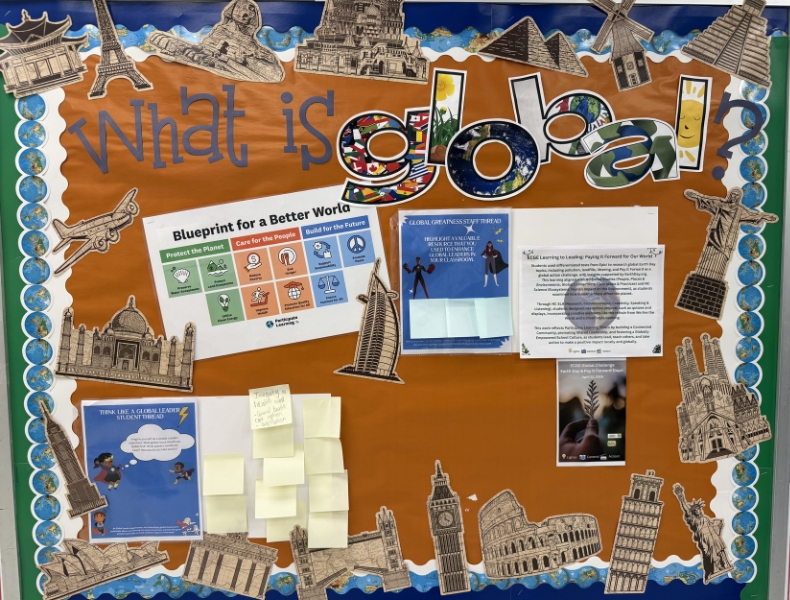 Elementary bulletin board reading “What is global?” with world landmarks and classroom materials supporting global learning and curriculum integration.