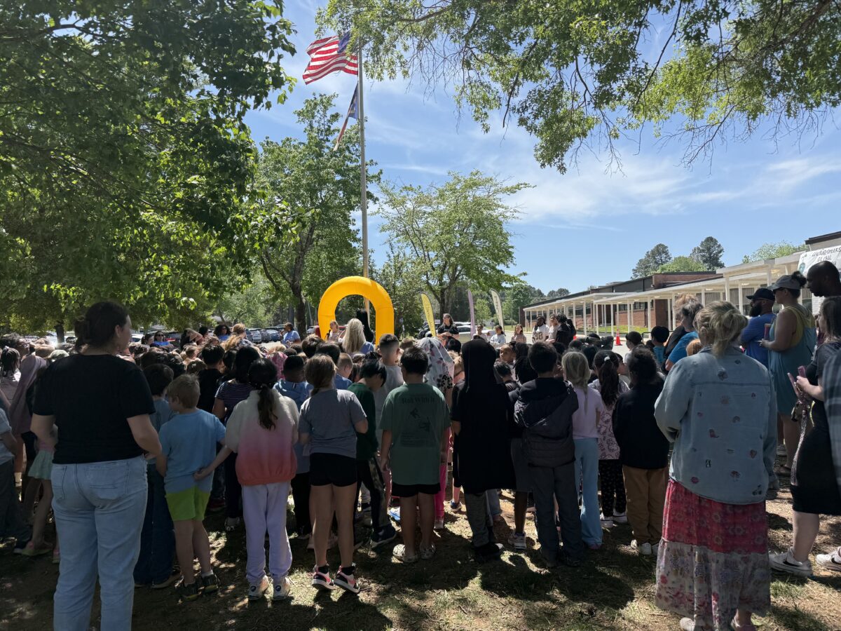 Students and staff gathered outside during the school's Earth Day event, reflecting a strong, connected school culture.