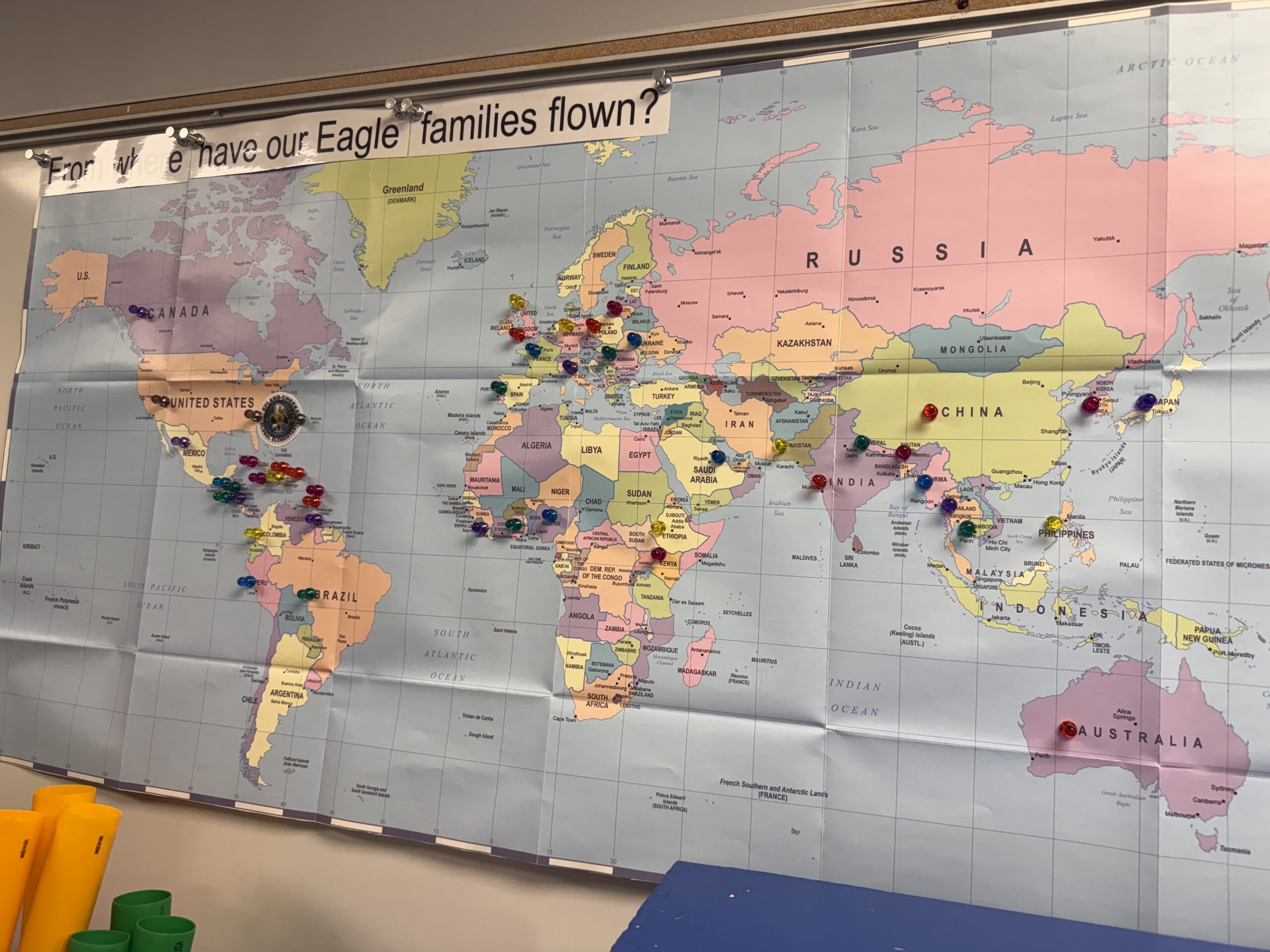 Classroom world map with the question "From where have our Eagle families flown?" with pins marking locations on the map.
