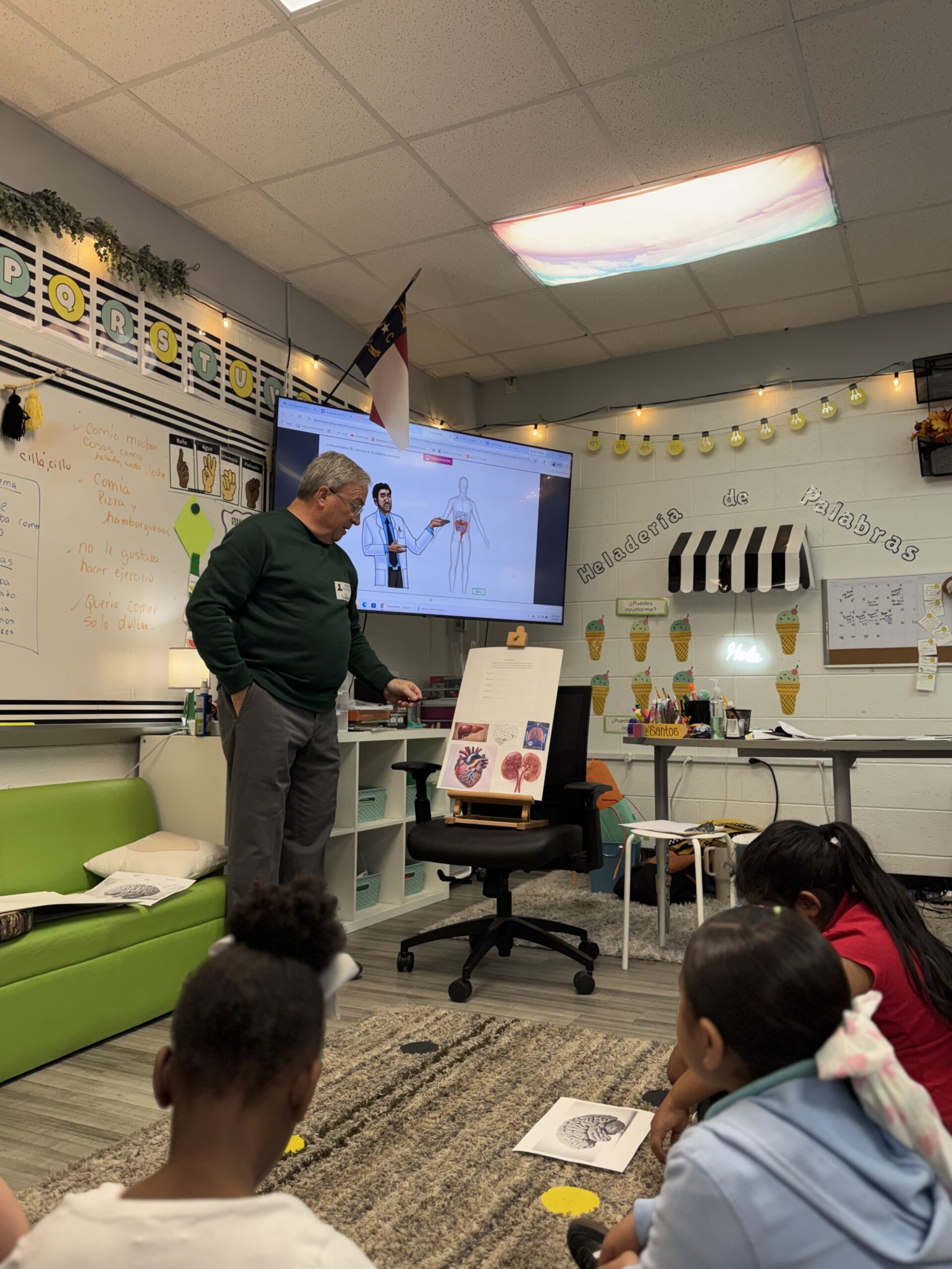 Guest speaker presenting about the human body to elementary students in a dual language classroom as part of a career exploration activity focused on healthcare careers.